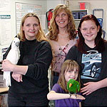 Triton Cockatoo, Wacko, poses with adopter Grace, MAARS Placement Counselor, Alayne, Grace's daughters, and Sydney, the family's Eclectus.